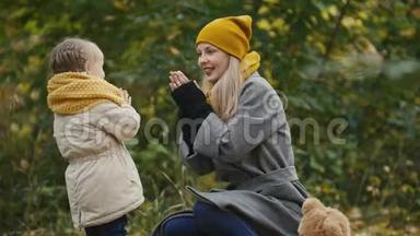 妈妈和她的女儿在一个秋天的公园里玩-妈妈和孩子玩得很开心，玩得很开心